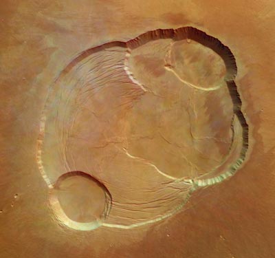 Voici la caldeira d'Olympus Mons, le plus grand volcan du système solaire culminant à 26 km d'altitude. La caldeira du volcan est formé d'une série d'anciens lacs de lave qui se sont peu à peu affaissés les un sur les autres donnant les formations visibles aujourd'hui. Les failles sont dues au poids énorme du volcan. Les falaises de la caldeira font 3 km et l'image, obtenue le 21 janvier, fait 102 km de côté.