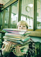 Boy holding a stack of picture books