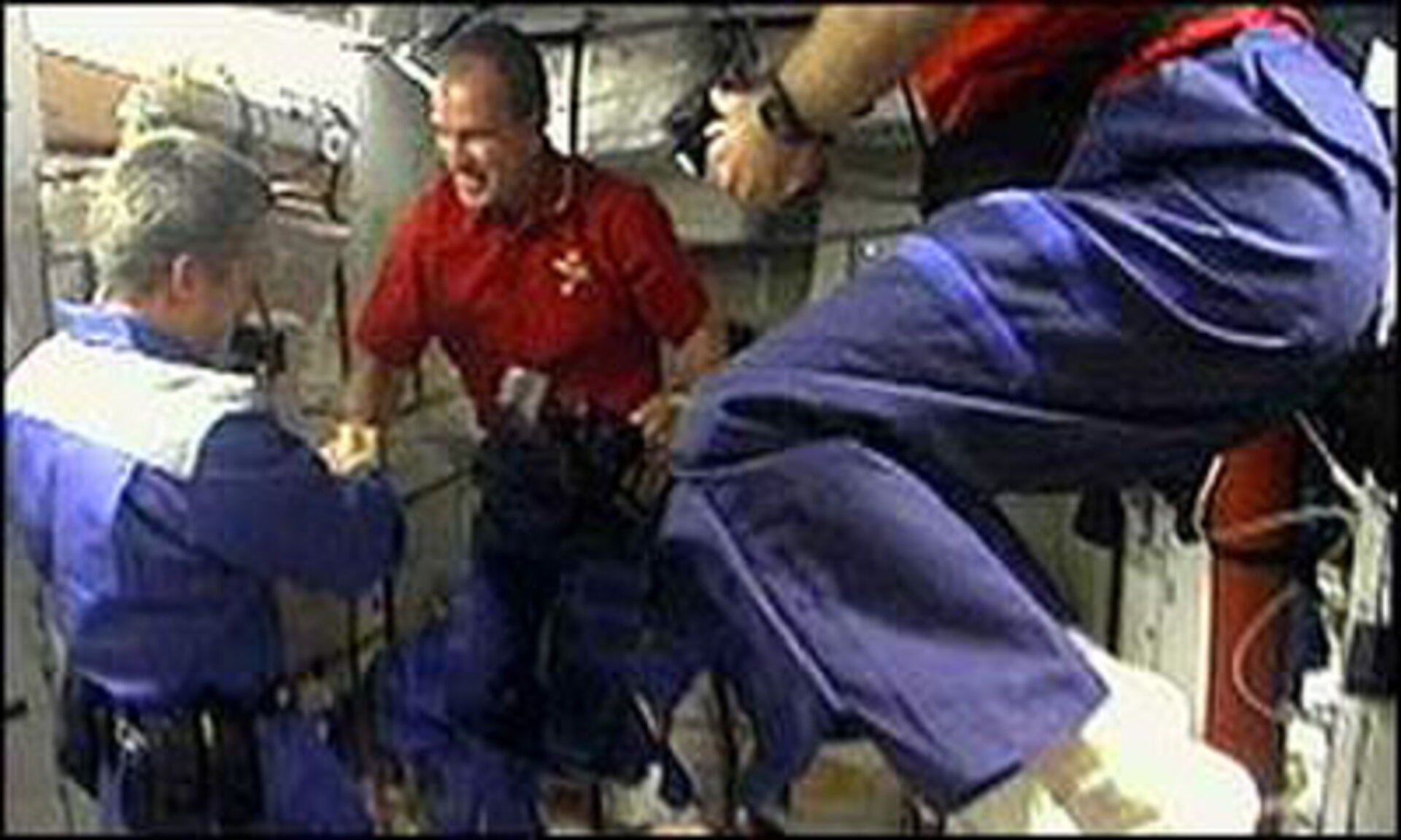 Brent Jett (in red) shakes hands with the ISS crew