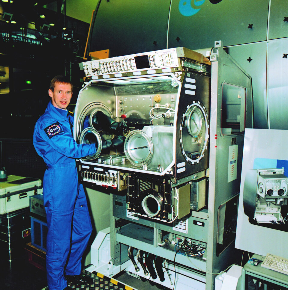 El astronauta Frank De Winne con la caja de guantes ("Glovebox") en la cual se realizan experimentos científicos en la ISS