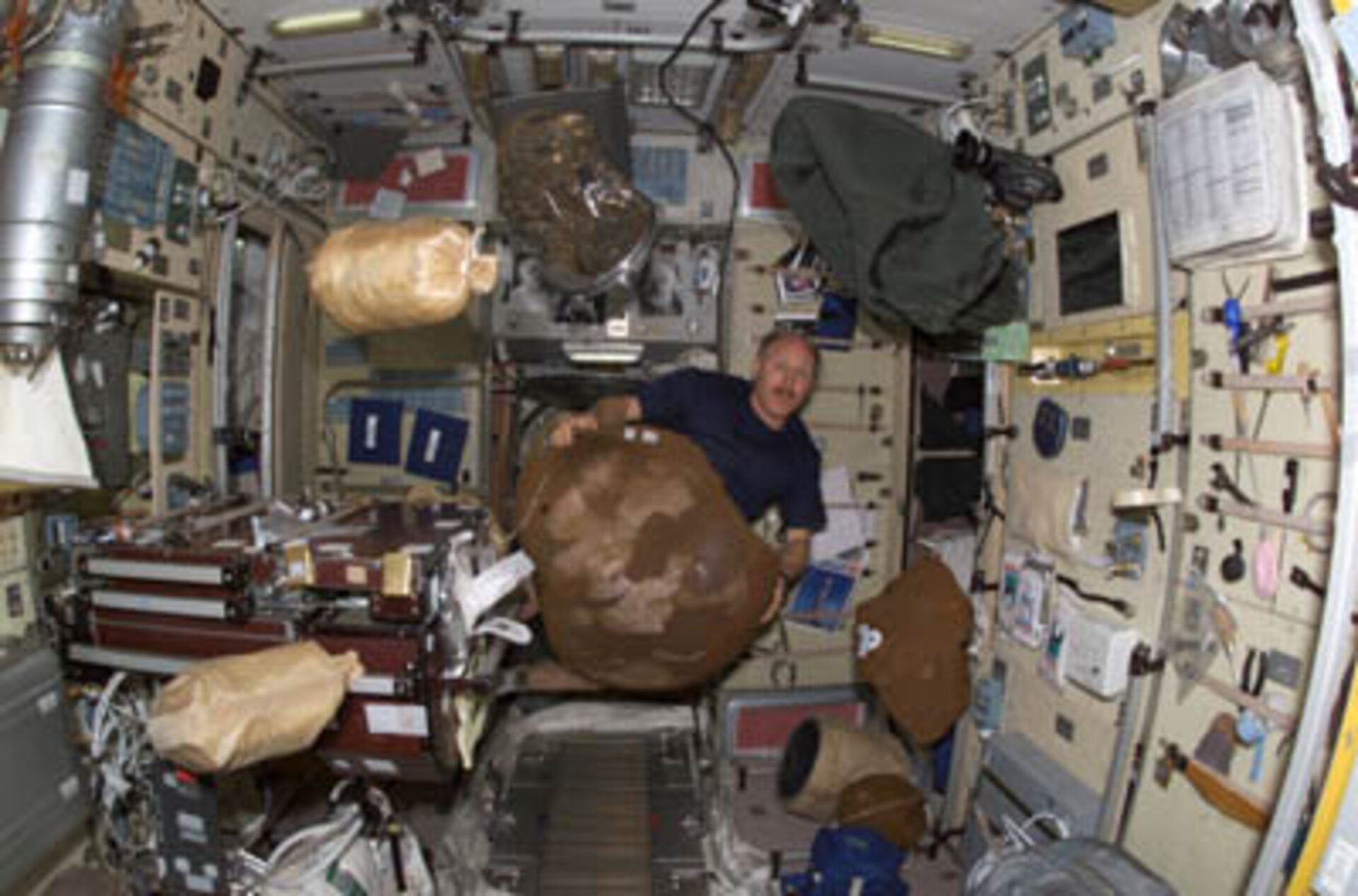 Astronaut Bowersox moves bagged items on ISS