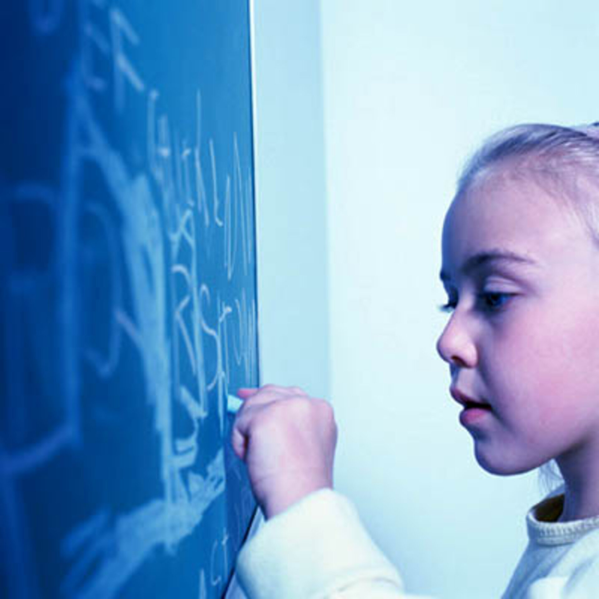 Elementary school girl writing on chalk board