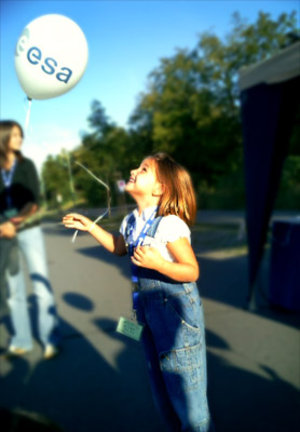 A young visitor releases a mock weather balloon