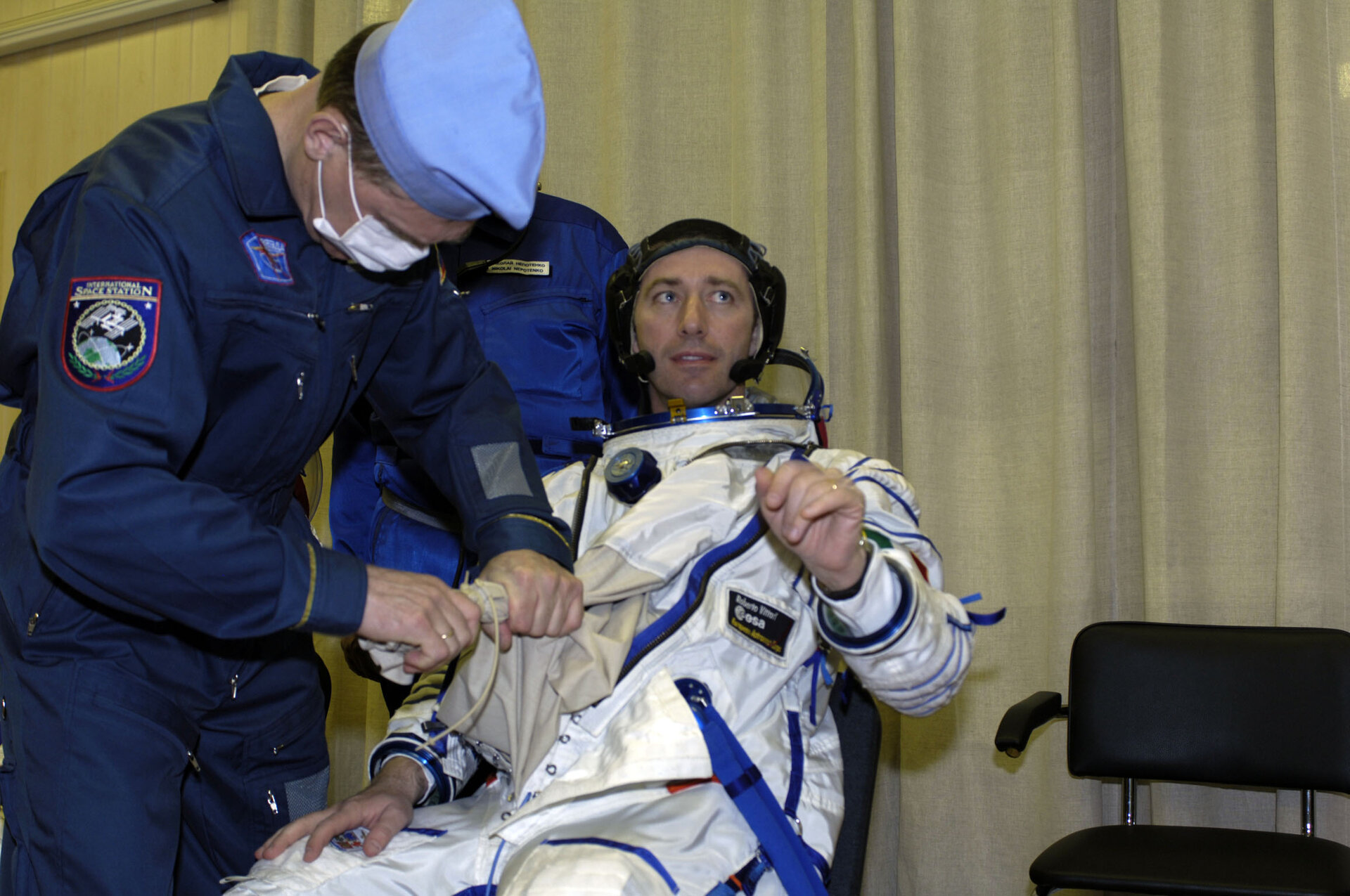Roberto Vittori is helped into his Sokol pressure suit ahead of the Soyuz TMA-6 launch