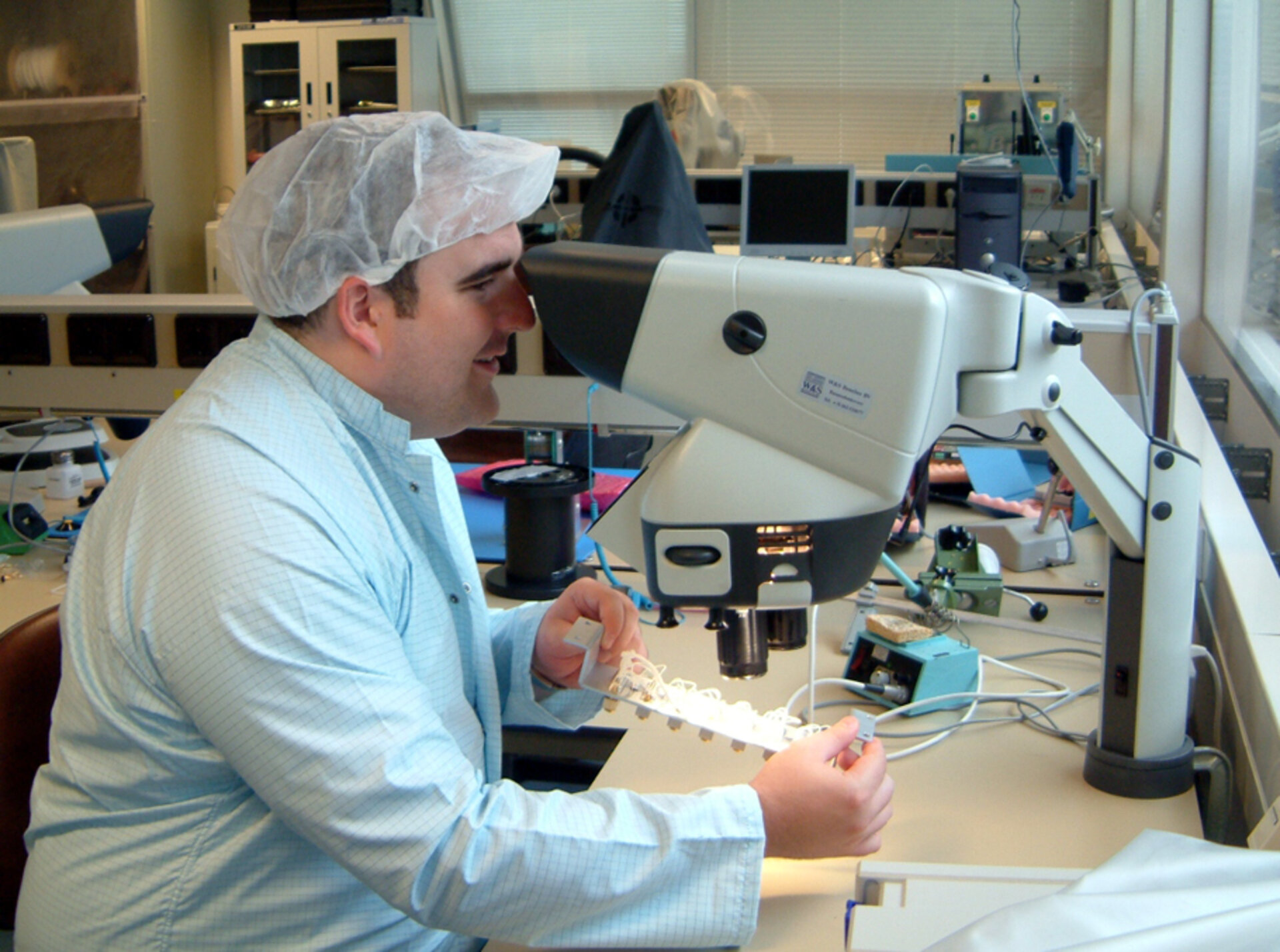 Neil Melville, project manager for SSETI Express, checking the power interface node soldering as it is delivered to ESTEC