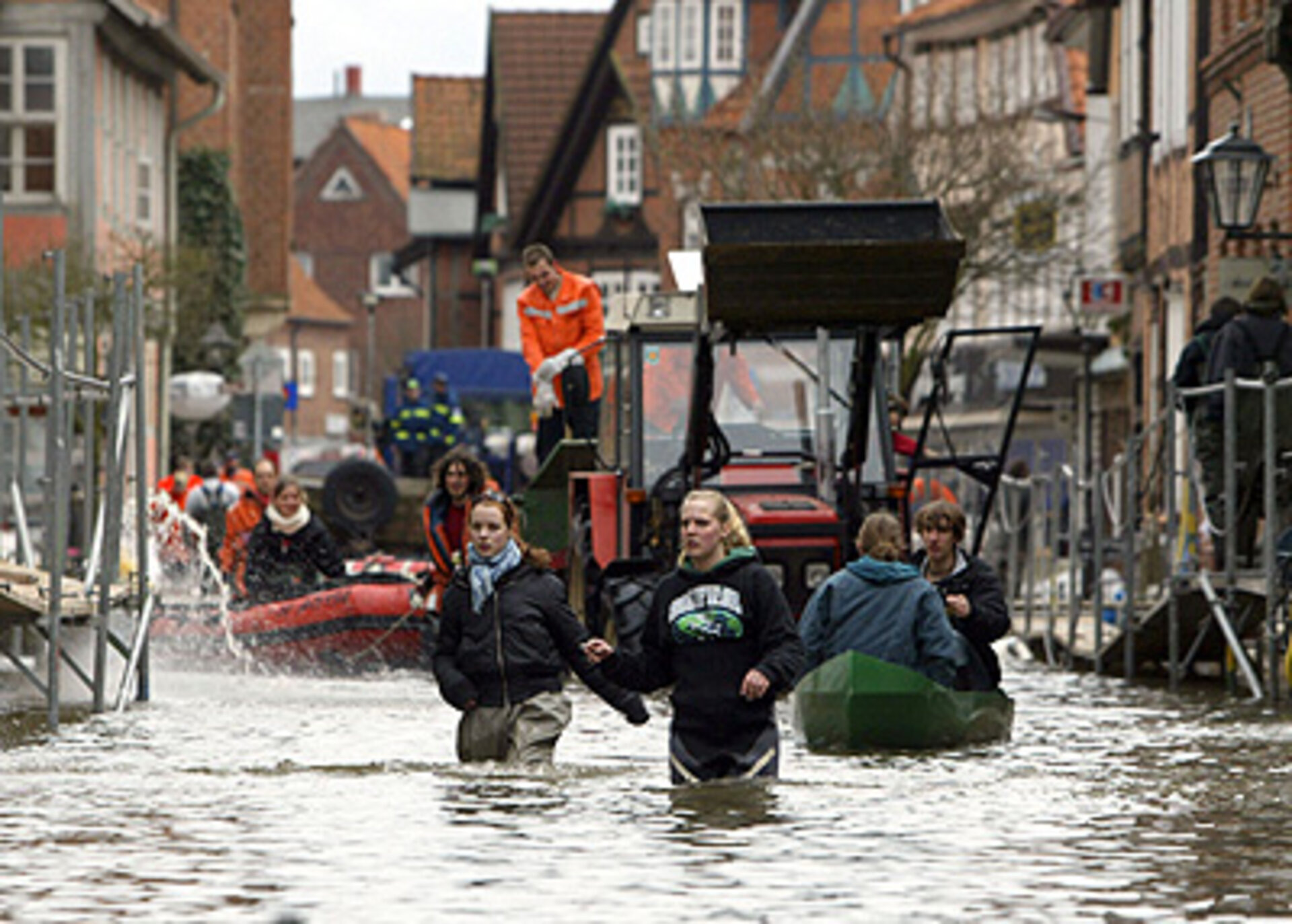 Residents make their way through a flooded street