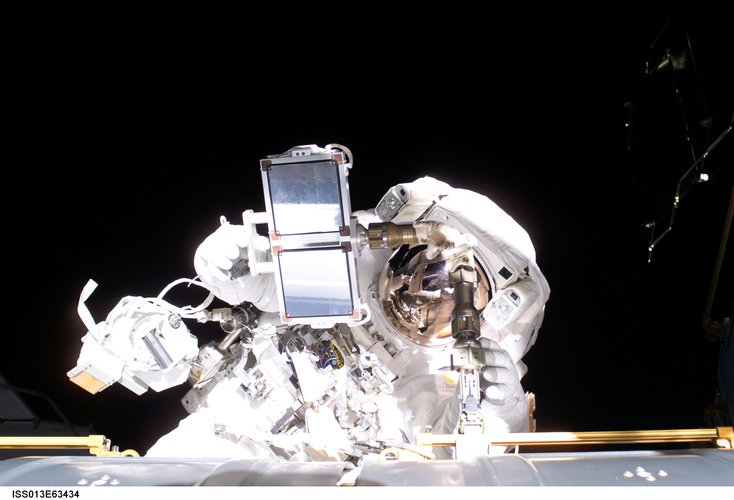 Thomas Reiter carries equipment for one final planned tasks during the spacewalk on 3 August 2006