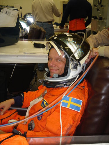 Christer Fuglesang is helped into his orange Advanced Crew Escape Suit (ACES) in preparation for the practice countdown