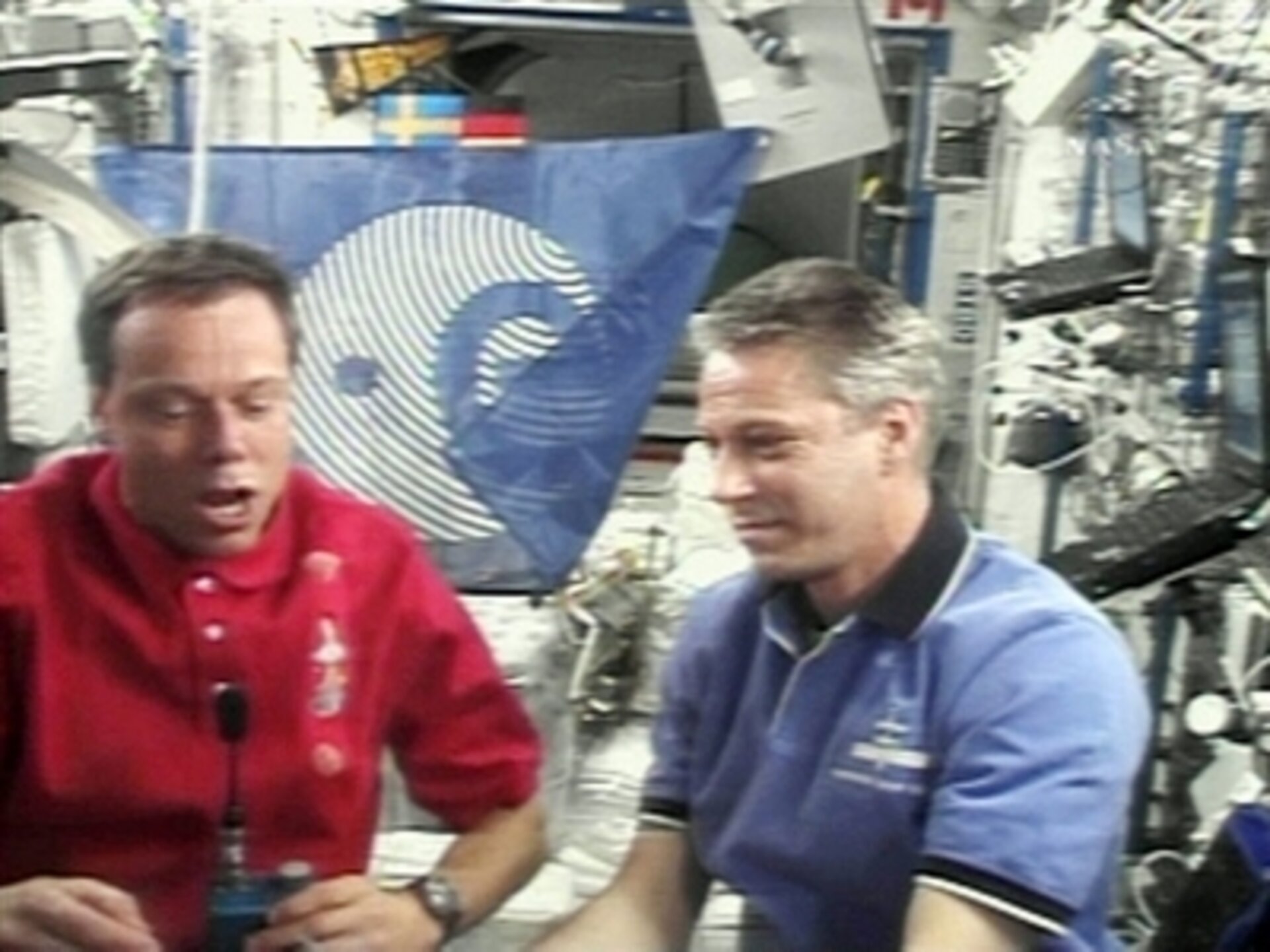 ESA astronauts Christer Fuglesang and Thomas Reiter demonstrate eating in space during an inflight call on 15 December 2006