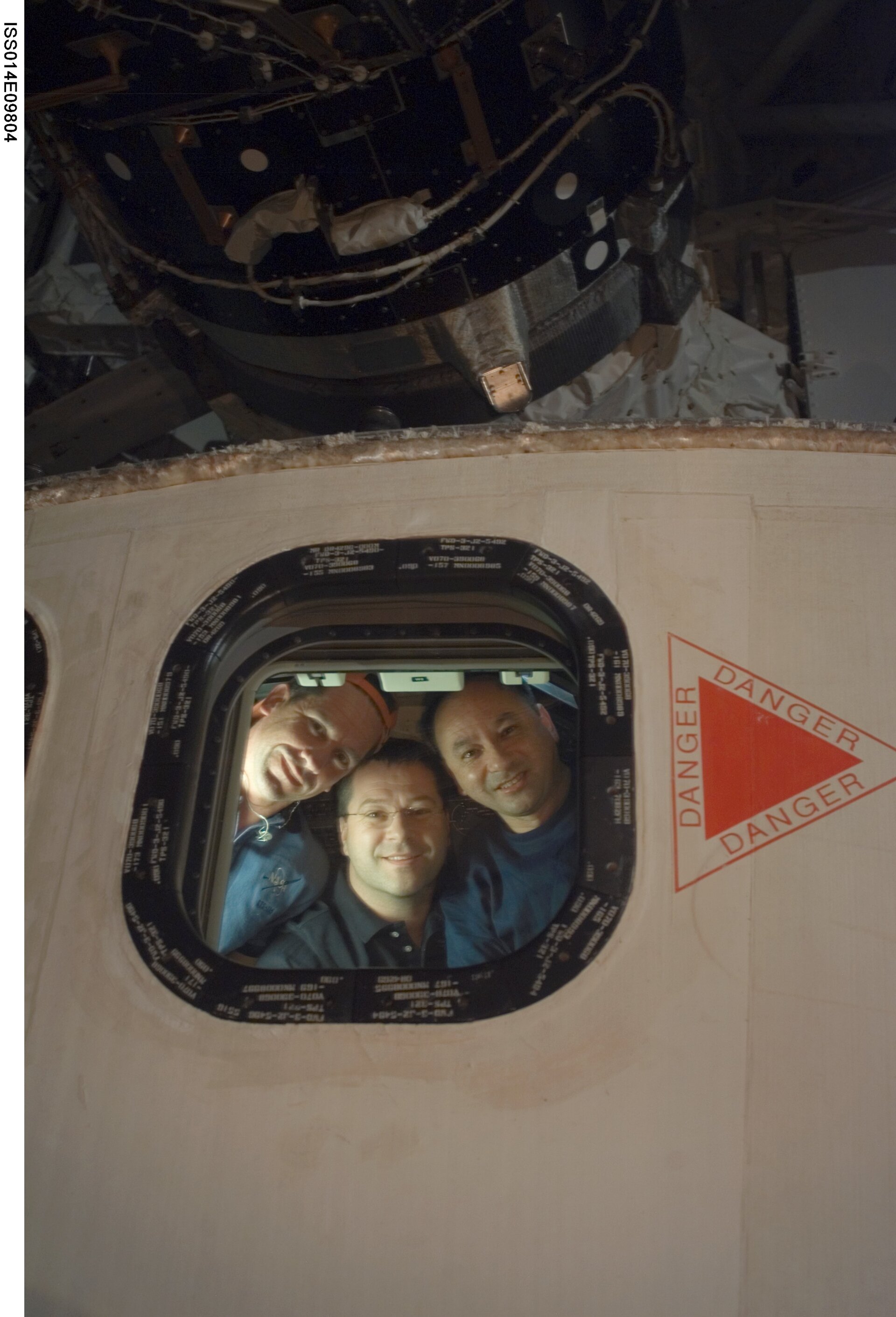 William Oefelein, Nicolas Patrick and Mark Polansky pictured through a Shuttle window