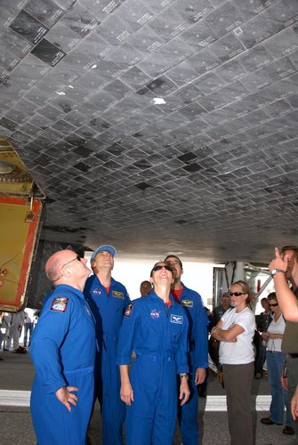 Members of the STS-118 crew take a close look at the damaged tile on the underside of Endeavour