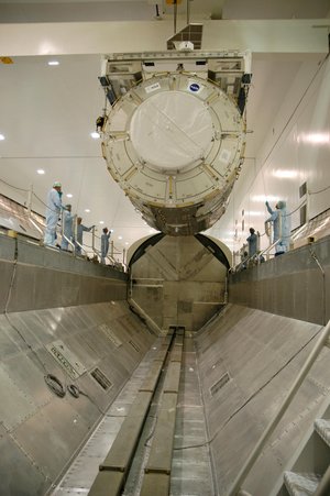 The U.S. Node 2 module, known as Harmony, is lowered into the waiting payload canister