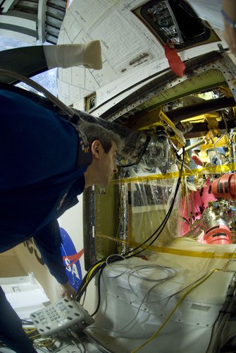 ESA astronaut Leopold Eyharts inspects Space Shuttle Atlantis