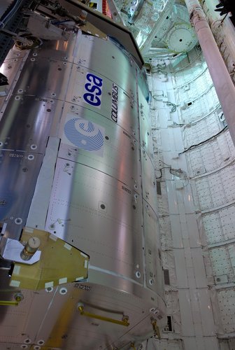 From inside the payload changeout room, the Columbus laboratory is moved into Space Shuttle Atlantis' payload bay