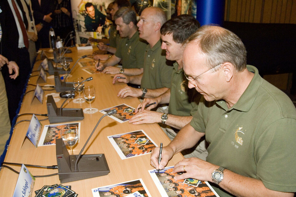 STS-122 crewmembers sign autographs following a presentation of their mission at ESTEC