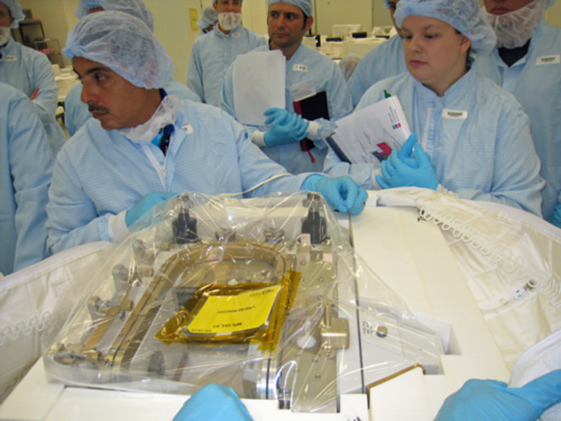 José med ett välinpackat och inplastat mikroskop som ska upp till ISS för experimentanvändning.