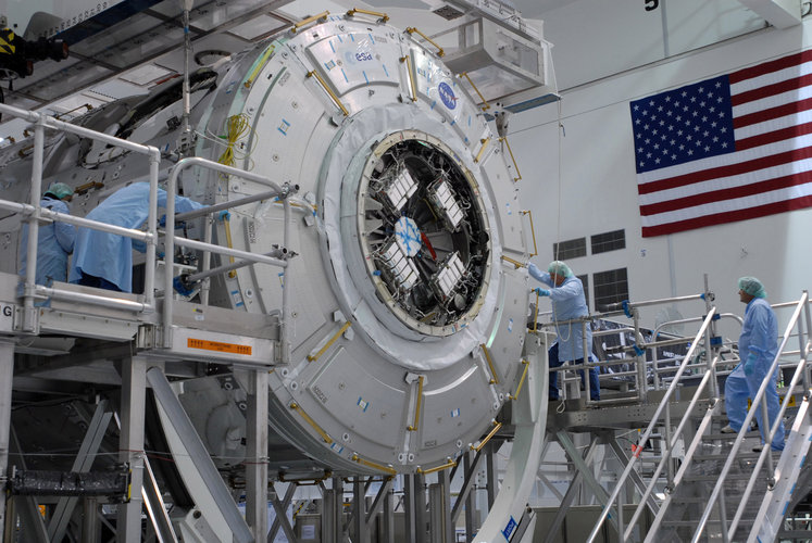 Node 3 is lowered onto a work stand in the Space Station Processing Facility at KSC
