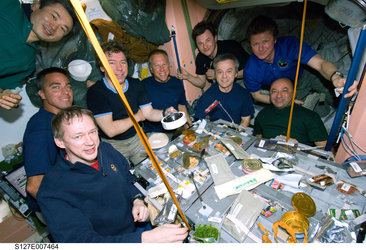 Astronauts and cosmonauts from Expedition 20 and STS-127 share a meal on the ISS