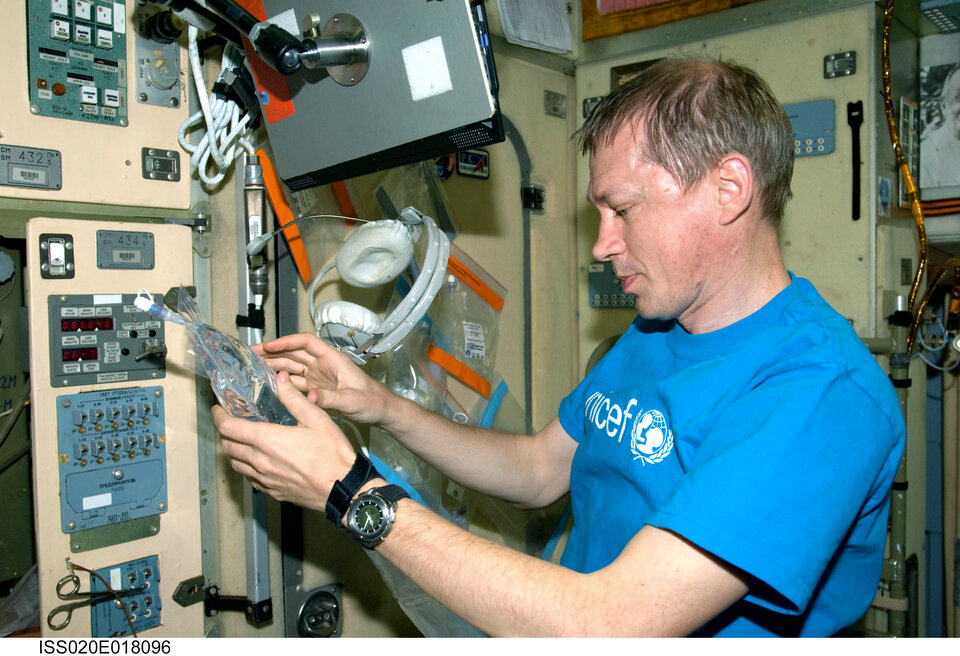Frank De Winne collects water samples for inflight analysis