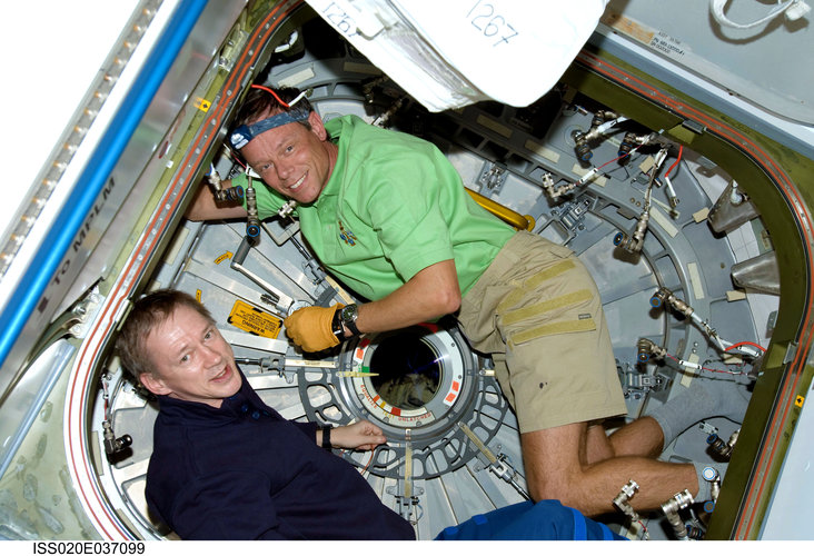 ESA astronauts Frank De Winne and Christer Fuglesang work inside the Harmony module