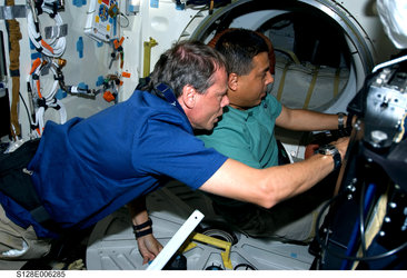 Fuglesang and Hernandez work on Shuttle middeck