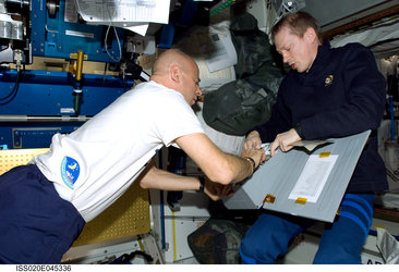 De Winne and Laliberte select food from a stowage container