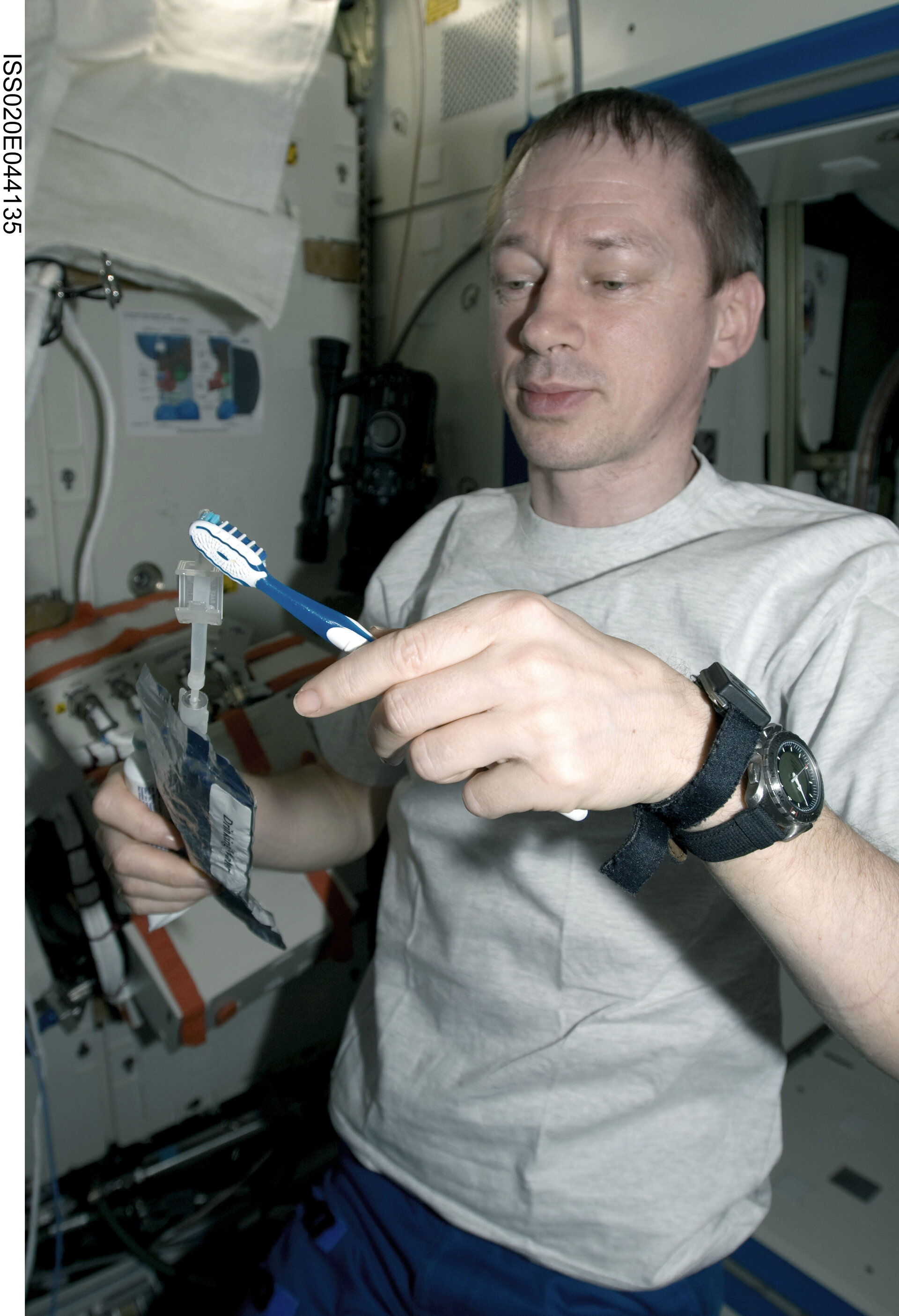 Frank De Winne squeezes water onto a toothbrush