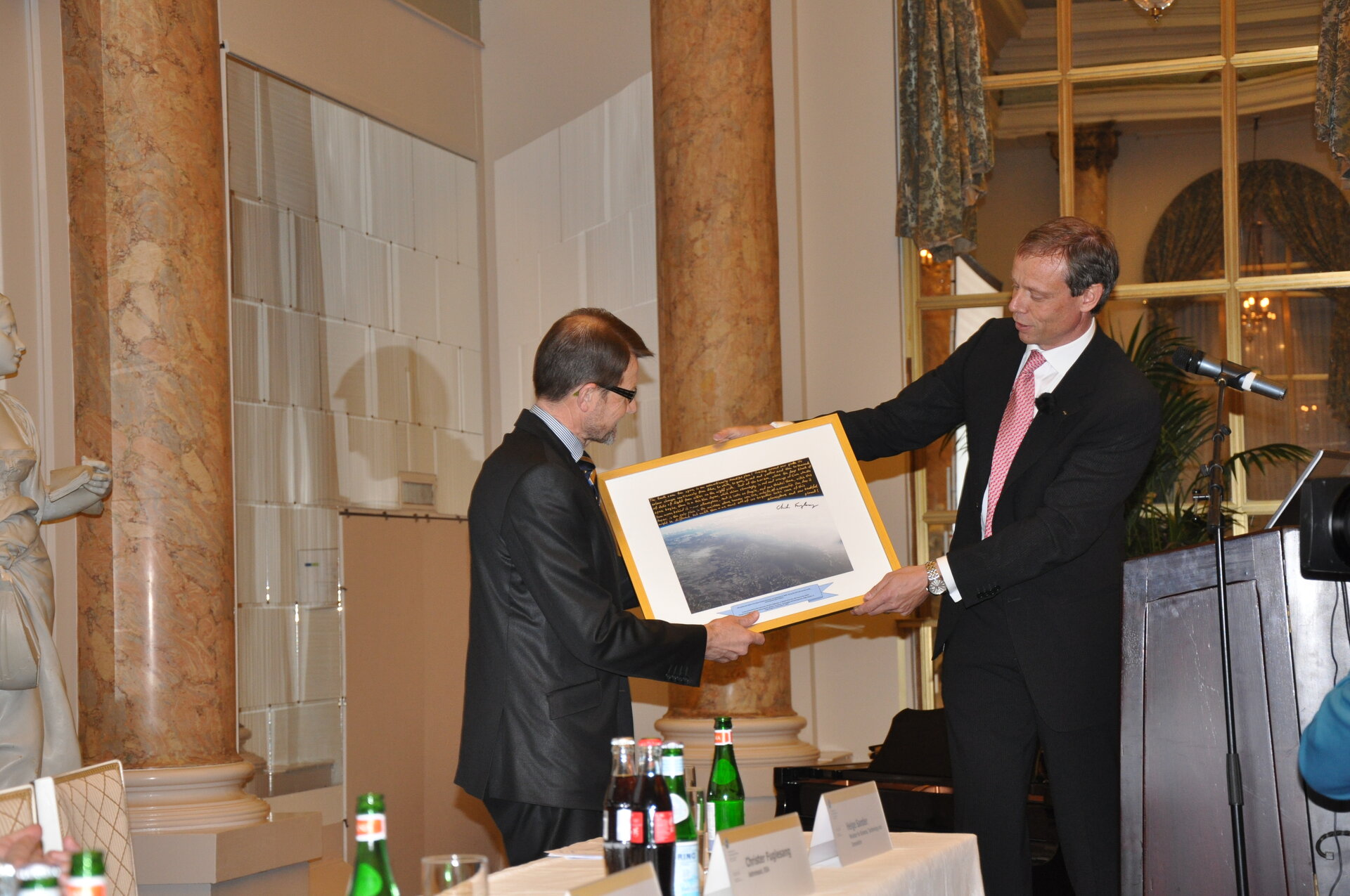 ESA astronaut C. Fuglesang (right) presenting a gift to H. Sander
