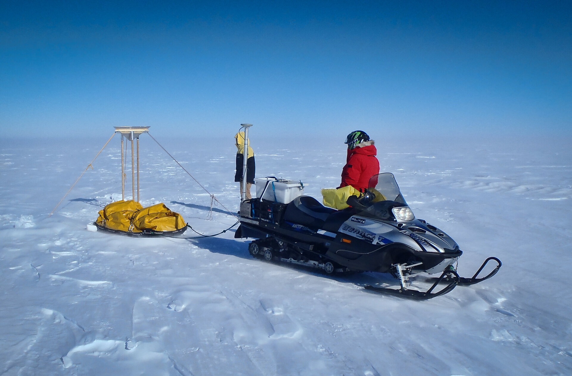 Mit Motorschlitten und Winkelreflektor in der Antarktis.