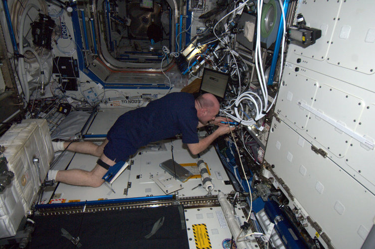 Andre Kuipers changing electronic module in ESA's Microgravity Science Glovebox