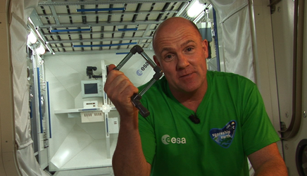 André Kuipers in het ISS met één van de educatieve experimenten.