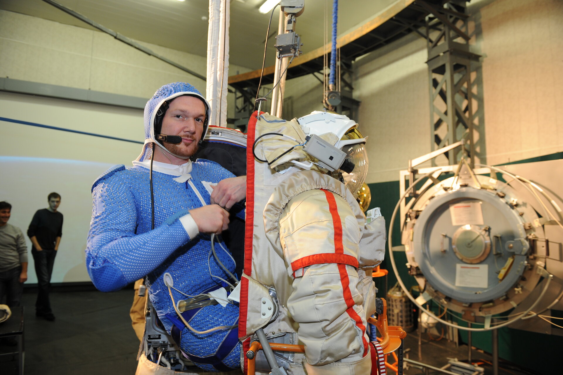 Alexander climbing into his spacesuit