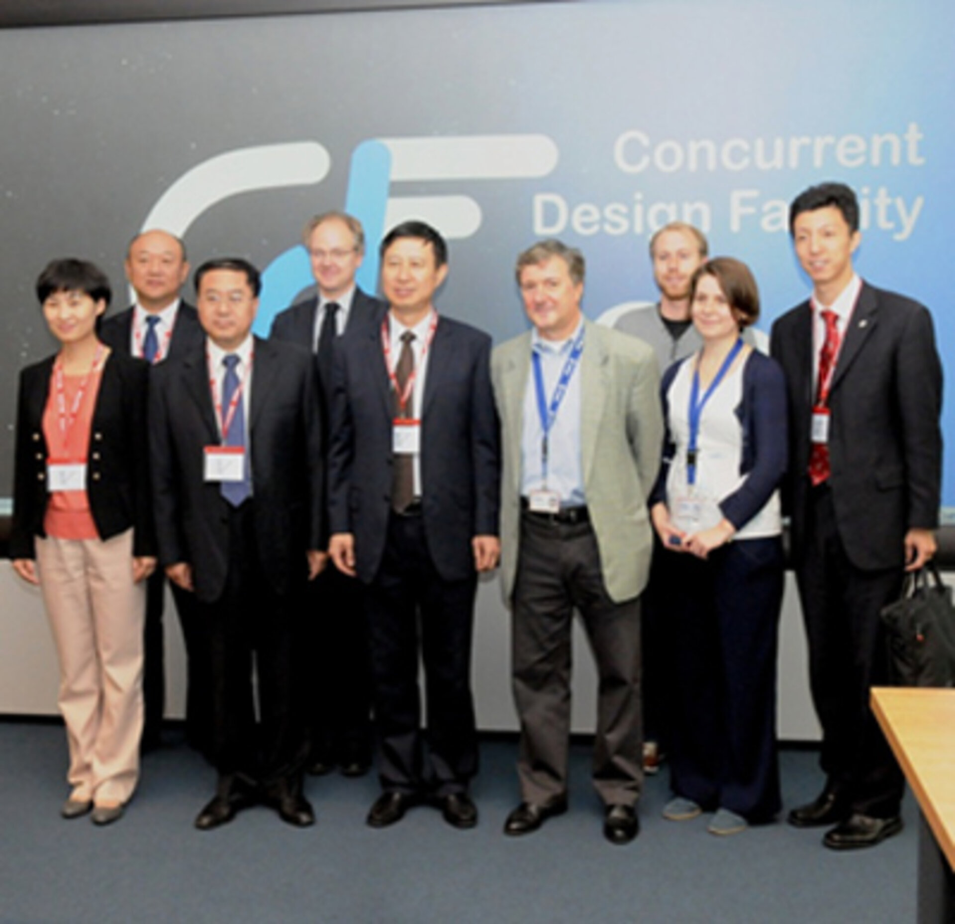 CMSEO Delegation and CDF staff pose for a picture in front of the multimedia wall