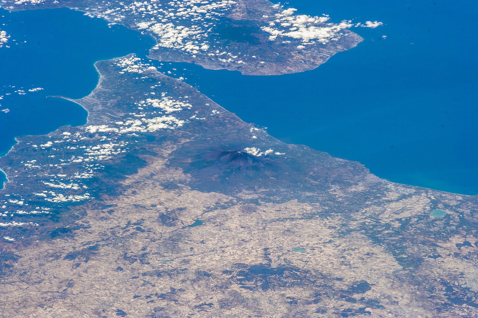 Etna rises above the terrain, a giant visible with the naked eye