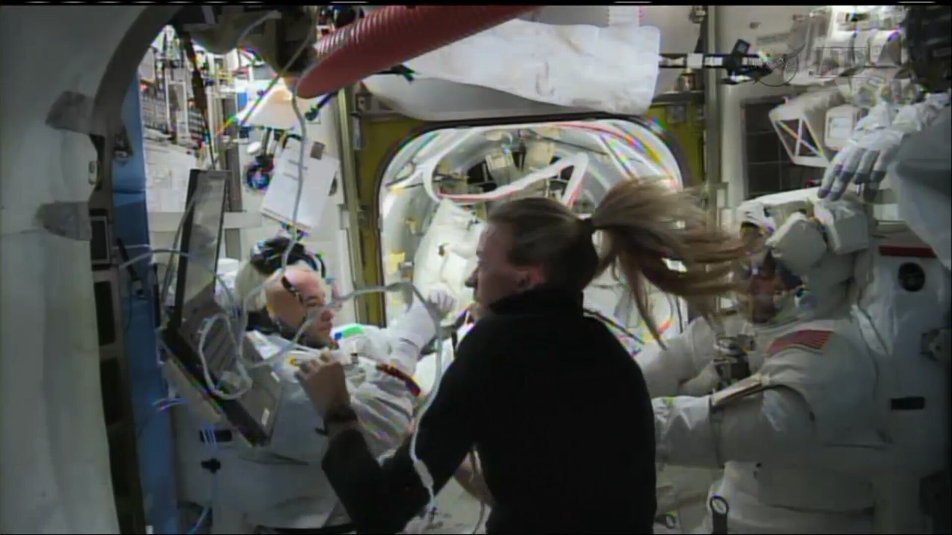 NASA astronaut Karen Nyberg helps Luca Parmitano remove his helmet and suit