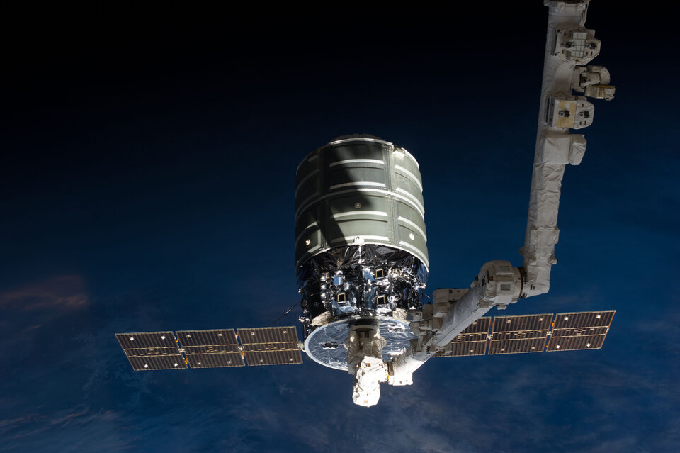 Der Raumfrachter Cygnus am Roboterarm der ISS