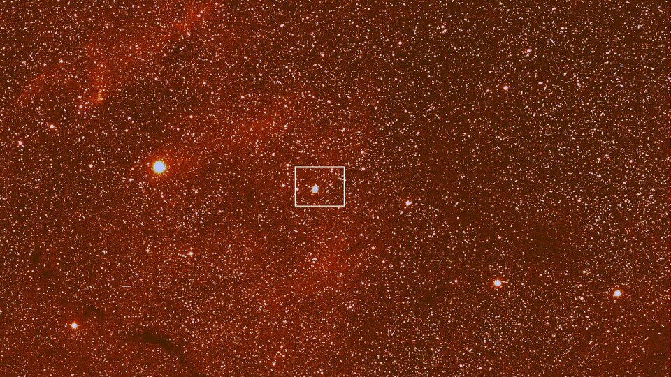 In der Weitwinkelansicht der OSIRIS-Kamera sind Wasserstoffgas und Staubwolken im Sternbild Ophiuchus zu erkennen. Der weiße Rahmen zeigt die Lage des Ausschnitts, der mit der Telekamera aufgenommen wurde.
