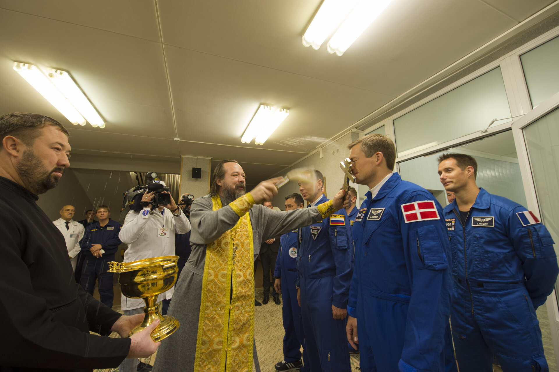 Crew members receive the traditional blessing from a Russian Orthodox priest