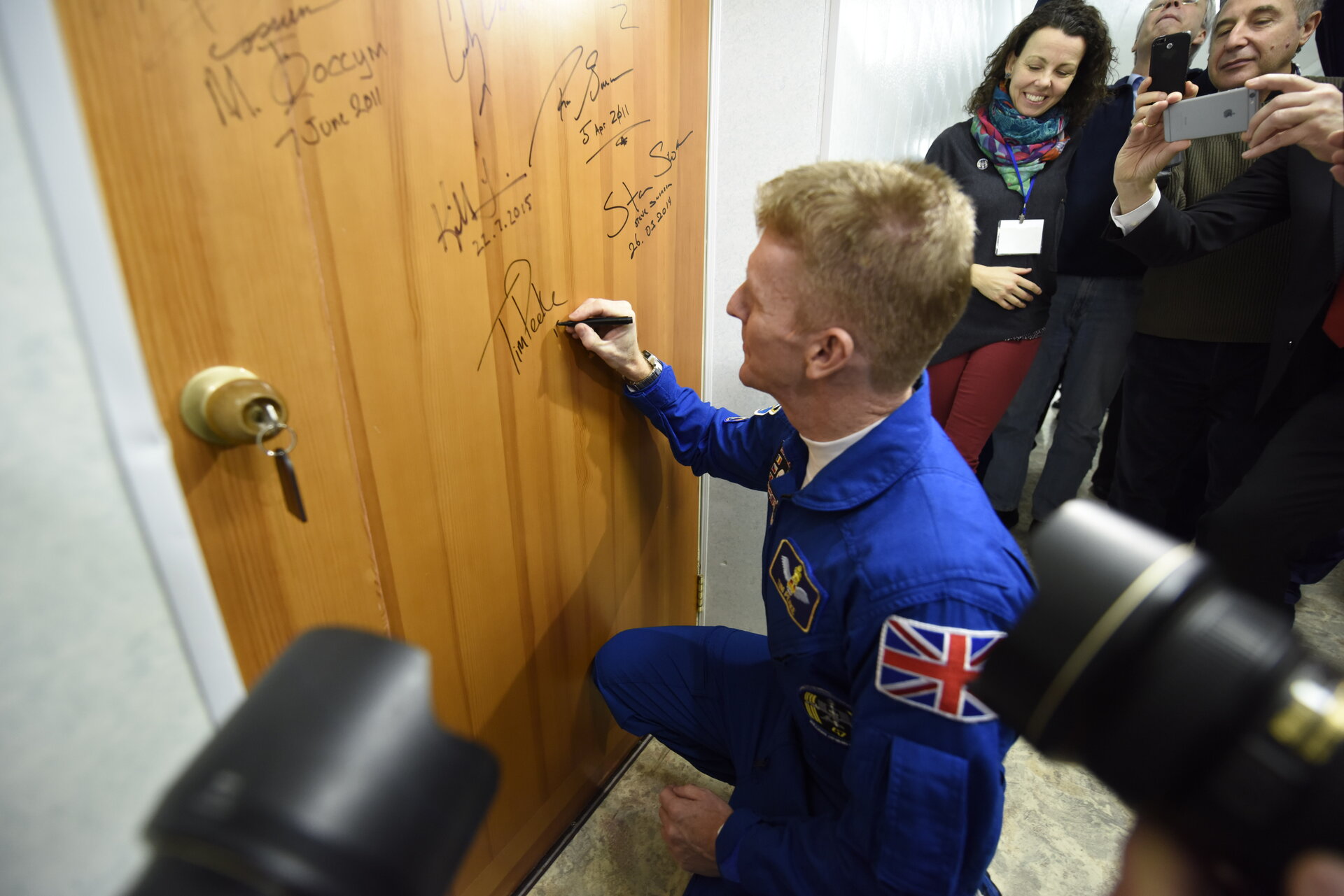 Tim Peake performs the traditional door signing at the Cosmonaut Hotel 