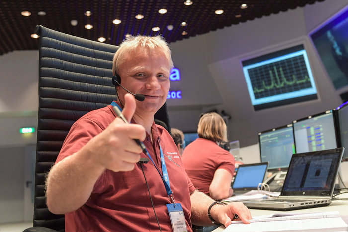 On 19 October 2016, Spacecraft Operations Manager Peter Schmitz gives the thumbs up in the main control room at ESA’s ESOC mission control centre shortly after the ExoMars Trace Gas orbiter (TGO) arrived at the Red Planet