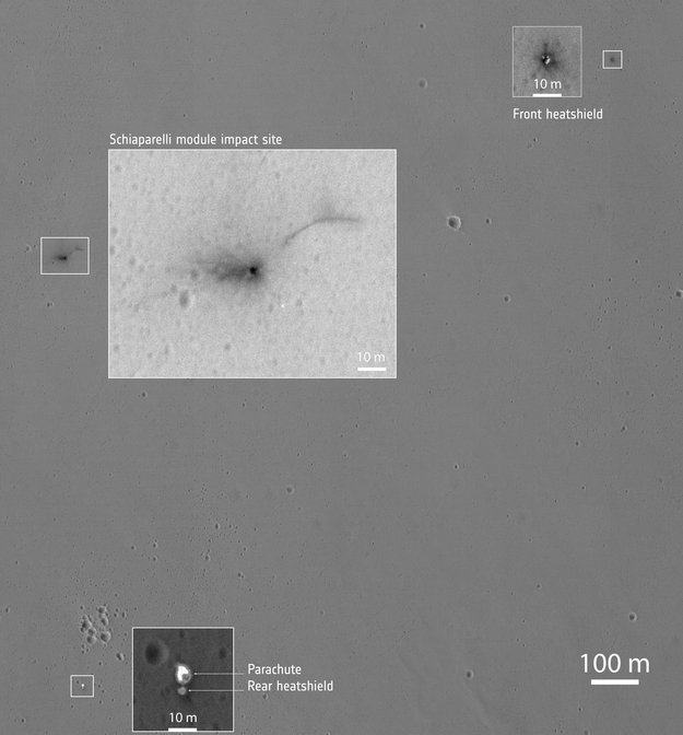 MRO ile 25 ekim'de alınmış görüntü. Altta aracın paraşütü ile alt ısı kalkanı, üstte ise ön ısı kalkanının izi görülüyor. Araç görüntü merkezinde koyu renkte bir krater oluşturmuş. Bu kraterin hemen sağ üstündeki yay benzeri yapının ne olduğu anlaşılamadı (NASA/JPL-Caltech/University of Arizona).