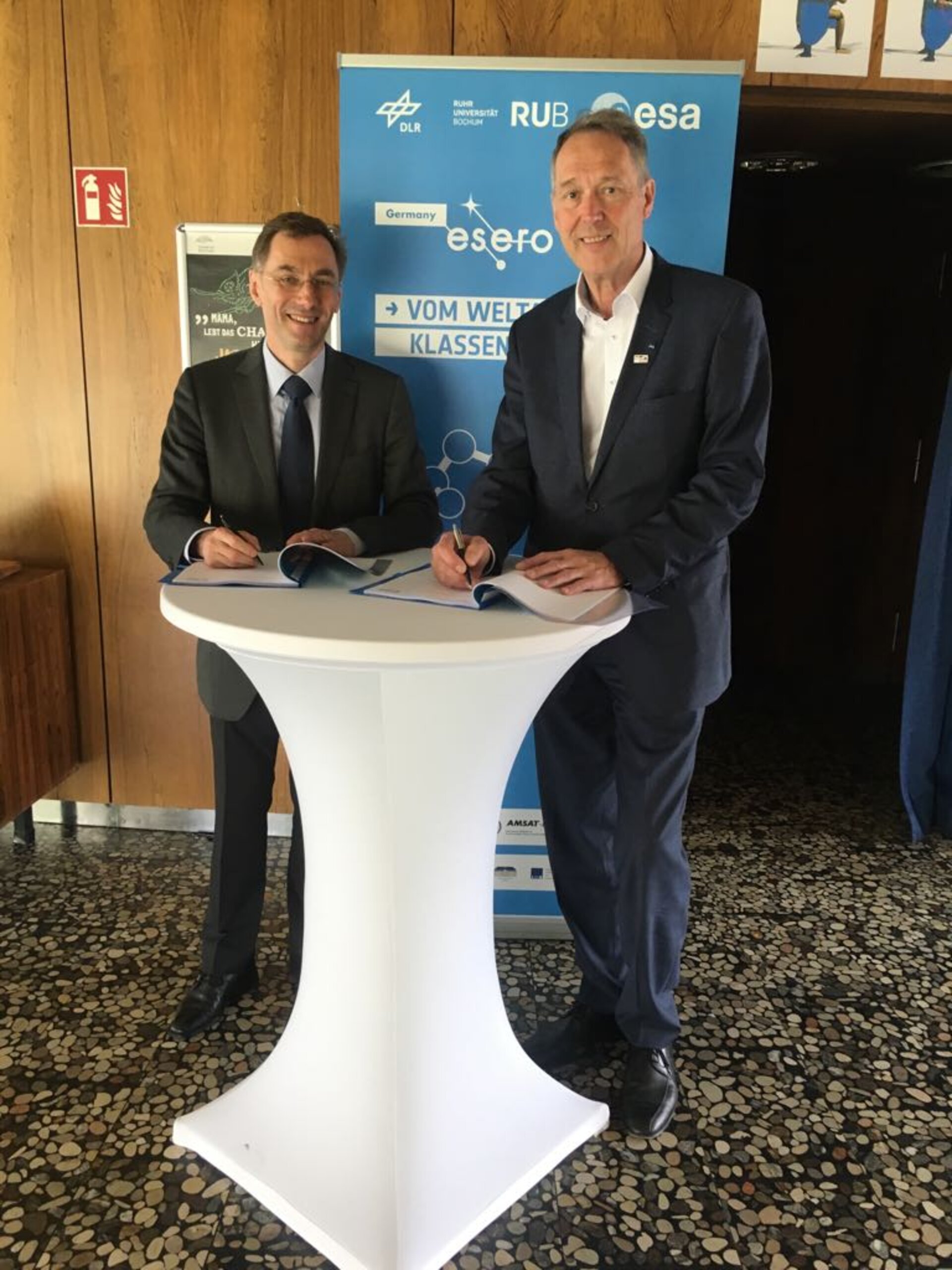 Kai-Uwe Schrogl und Axel Schölmerich unterzeichnen den Vertrag