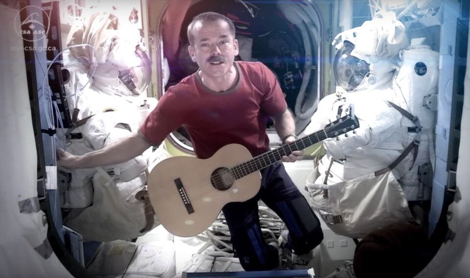Un astronauta toca la guitarra en el espacio