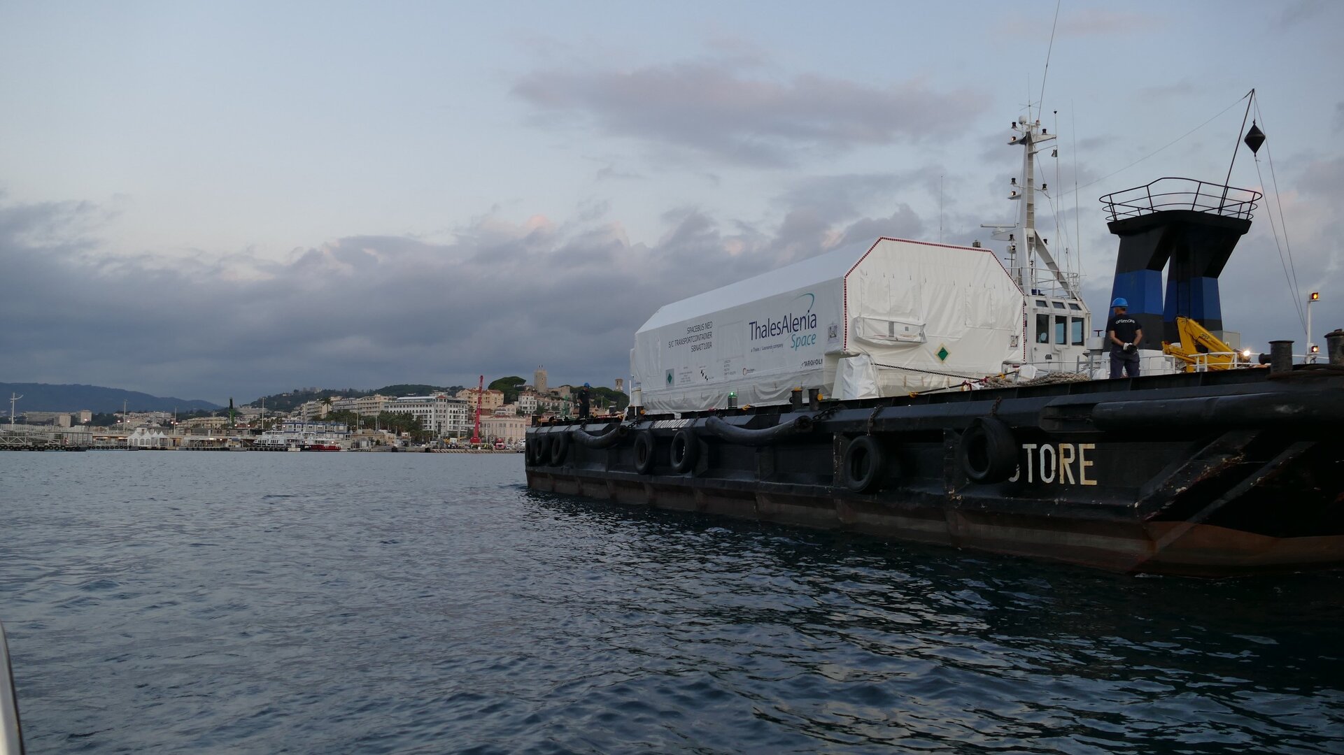 The enormous satellite container aboard a barge in the port of Cannes