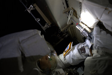 Luca removes fasteners by helmet light during first AMS spacewalk