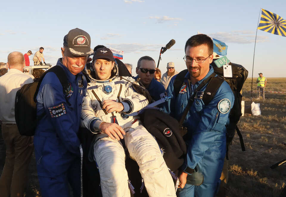 Romain Charles (à droite) aide à porter l'astronaute Thomas Pesquet quelques minutes après son retour sur Terre suite à sa première mission de six mois à bord de la Station.
