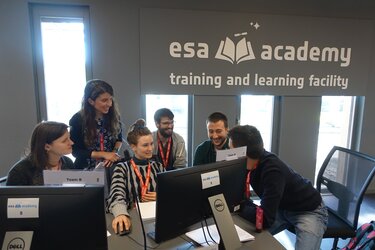 University students working with a trainer on the Group Project