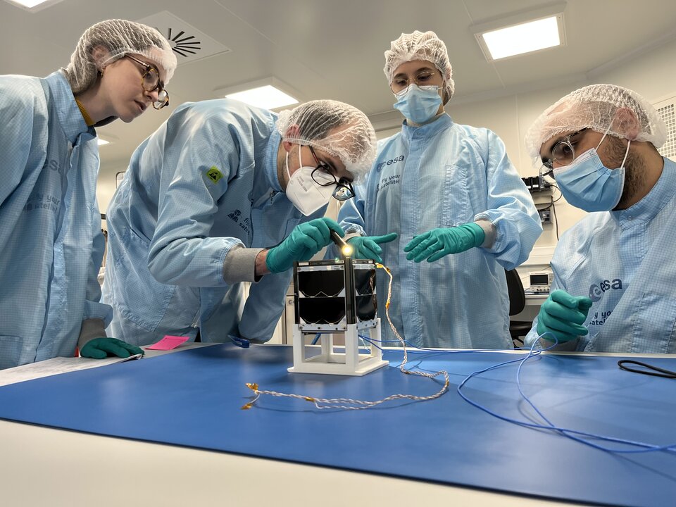 ISTSat-1 students inspecting their CubeSats in the CSF