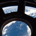 Earth and its horizon seen through the windows in the Cupola