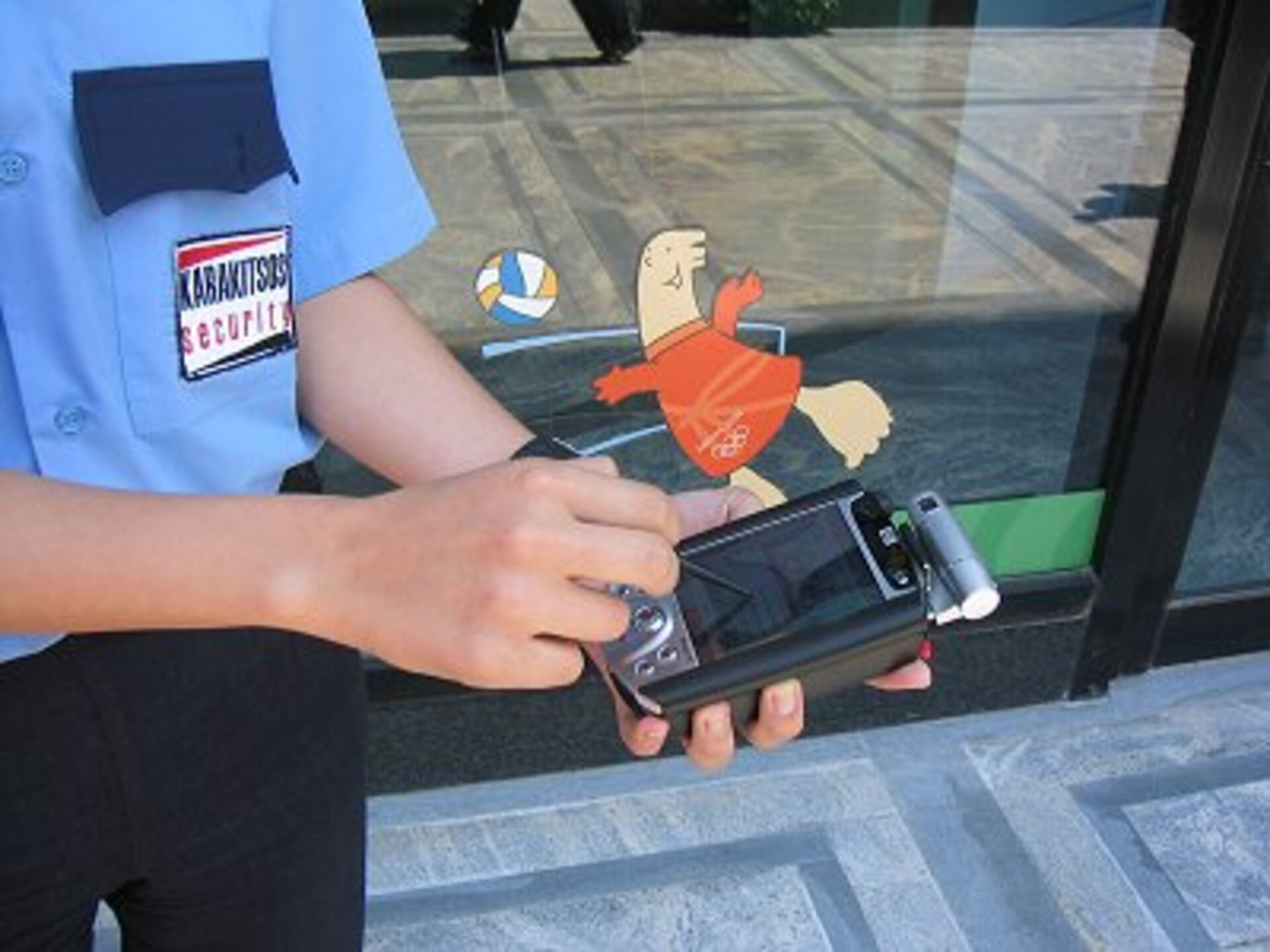 Guard on duty near Olympic stadium with special handheld device